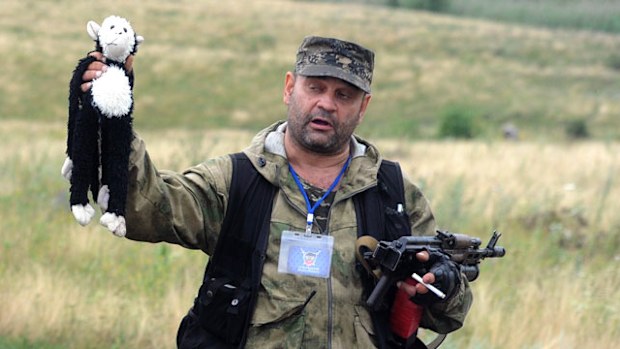 A pro-Russia militant holds up a stuffed animal as others look on at the site of the crash of a Malaysian airliner. (Getty)