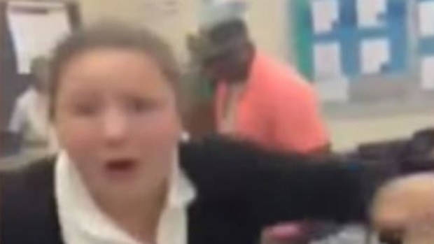 A student runs away as the teacher advances brandishing a belt. (Supplied)