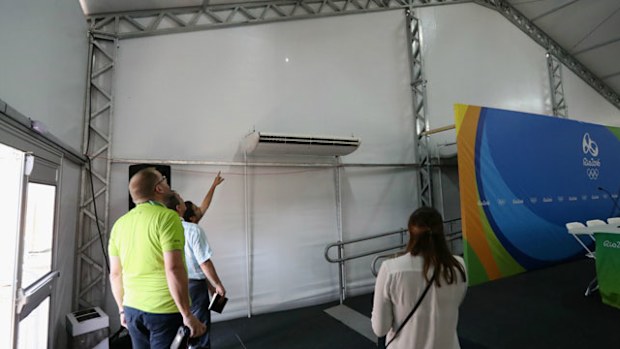 Staff from the Olympic Equestrian Centre's  media room inspect the bullet hole. Photo: Getty