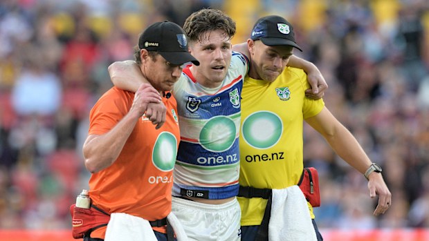 Luke Metcalf of the Warriors is helped from the field after suffering a leg injury.