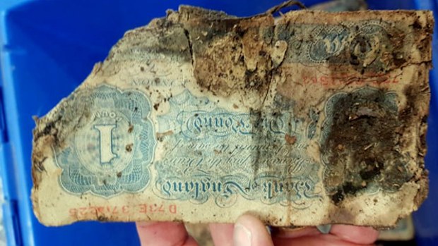 The blue-tinted note found as part of a cash hoard beneath an English shop indicates it was issued as emergency currency in Britain during World War II.