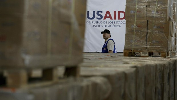 A man walks past boxes of USAID humanitarian aid at a warehouse at the Tienditas International Bridge on the outskirts of Cucuta, Colombia, Feb. 21, 2019.