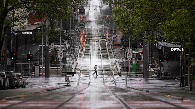 A lone person is seen crossing Bourke Street Mall  in Melbourne.