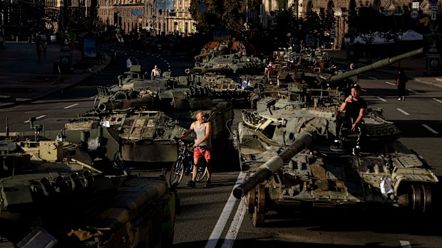 People walk around destroyed Russian military vehicles installed in downtown Kyiv, Ukraine, Wednesday, Aug. 24, 2022. Kyiv authorities have banned mass gatherings in the capital through Thursday for fear of Russian missile attacks. Independence Day, like the six-month mark in the war, falls on Wednesday. (AP Photo/Evgeniy Maloletka)
