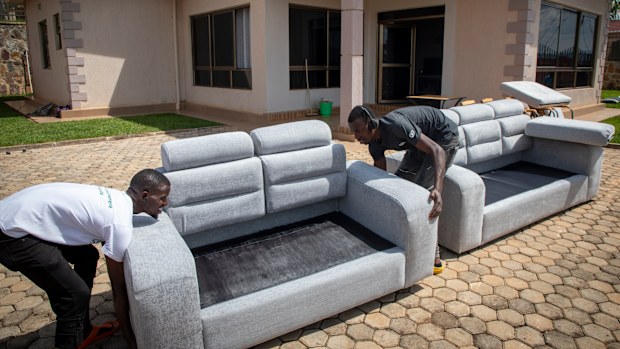 FILE - People carry furniture into the newly refurbished Hallmark Residences, which is one of the locations expected to house some of the asylum-seekers due to be sent from Britain to Rwanda, in the capital Kigali, Rwanda on May 19, 2022. A group of asylum-seekers asked a U.K. court on Friday, June 10, 2022 to stop the British government sending them on a one-way flight to Rwanda. (AP Photo/File)