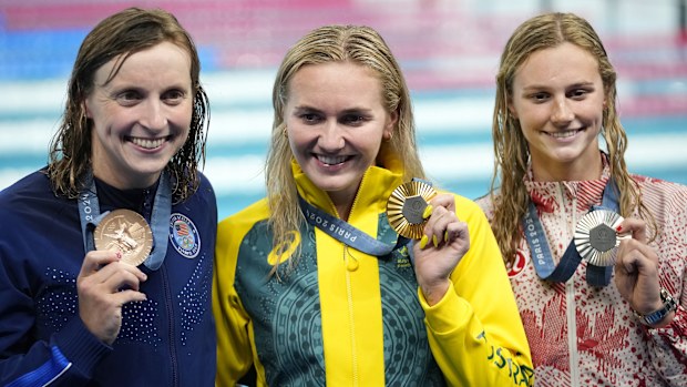Gold medalist Ariarne Titmus, of Australia, middle, stands with silver medalist Summer McIntosh, of Canada, right, and bronze medalist Katie Ledecky, of the United States, after winning the women's 400-meters freestyle final the at the 2024 Summer Olympics, Saturday, July 27, 2024, in Nanterre, France. (AP Photo/Petr David Josek)