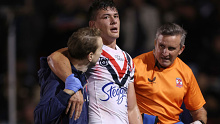 Roosters half Joseph Manu is assisted off the field after an ankle injury.