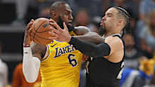 LeBron James of the Los Angeles Lakers handles the ball against Dillon Brooks.