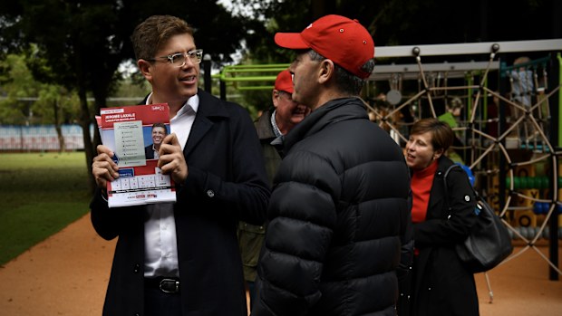 Jerome Laxale hands out how to vote forms to waiting crowds at West Ryde Public School, Sydney, Saturday 21 May, 2022.