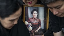 BANGKOK, THAILAND - OCTOBER 26: Mourners react to the passing of the late Queen Mother Sirikit while holding a framed portrait of her on October 26, 2025 in Bangkok, Thailand. Thailand's Queen Mother Sirikit, revered as a symbol of unity and grace, has died peacefully in Bangkok at the age of 93, marking the end of an era for the nation. Her passing has prompted a national period of mourning. (Photo by Sirachai Arunrugstichai/Getty Images)