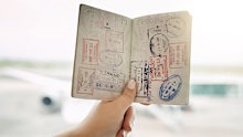 POV shot of an unrecognizable woman holding a passport indoors
