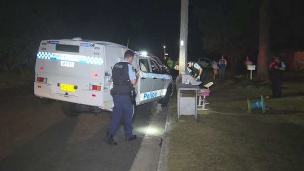 Police on a street at night after a man was seriously injured while riding his motorcyle. 
