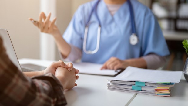 Close-up hand image of a serious patient having a medical consultation with a professional doctor at a hospital. Medical checkup, counseling, and diagnosis of disease