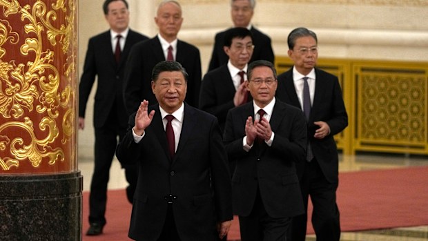 New members of the Politburo Standing Committee, front to back, President Xi Jinping, Li Qiang, Zhao Leji, Wang Huning, Cai Qi, Ding Xuexiang, and Li Xi arrive at the Great Hall of the People in Beijing.