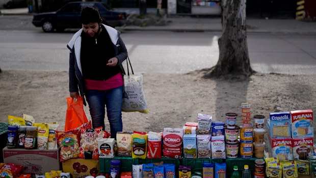A shopper looks at food displayed at a market where clients can buy or barter.