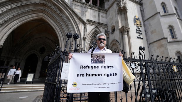 Protestors stand outside The Royal Court of Justice in London, Friday, June 10, 2022. The High Court will hear a legal challenge lodged by Care4Calais, the Public and Commercial Services Union (PCS) and Detention Action, opposing the Home Office's new asylum deal with Rwanda. The case alleges that Priti Patel's proposals are in contravention of international law and the UN refugee convention. (AP Photo/Frank Augstein)