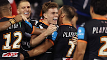 Lachlan Galvin of the Tigers celebrates with team mates after scoring a try.
