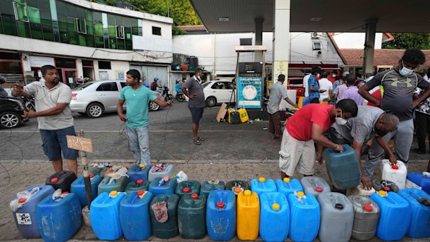 Sri Lankans gather at a fuel station to buy diesel before the beginning of curfew in Colombo after a state of emergency was declared by the President. 
