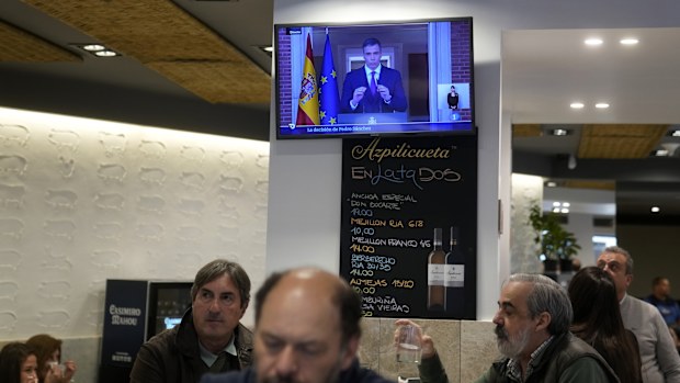 Customers have breakfast in a restaurant while Spanish Prime Minister Pedro Sanchez appears on a television broadcast in Madrid, Spain, Monday, April 29, 2024. 