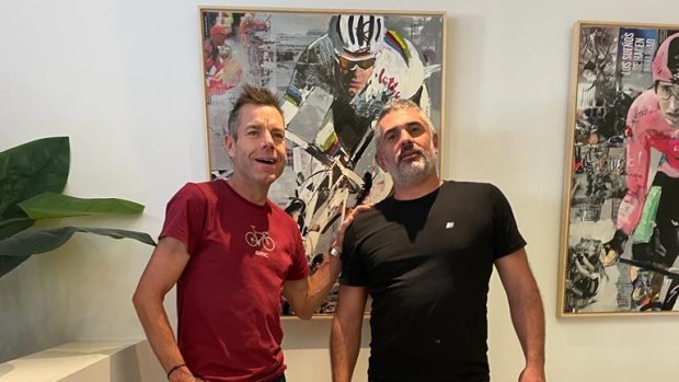 Cadel Evans and artist Miguel Soro pose with Soro's painting of Evans.