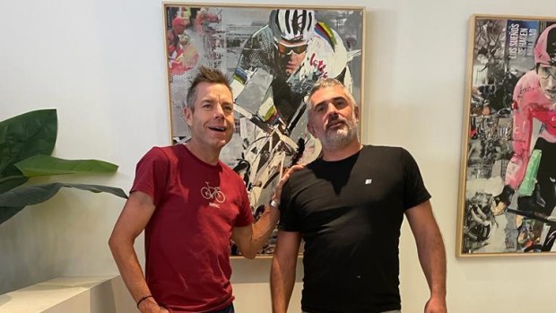 Cadel Evans and artist Miguel Soro pose with Soro's painting of Evans.