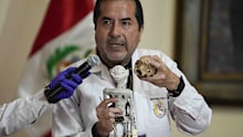 Forensic archaeologist Flavio Estrada from Peru's prosecutor's office shows a doll, which was seized by authorities before it was shipped to Mexico, during a press conference to explain what it is made of at the Archeology Museum in Lima, Peru, Friday, Jan. 12, 2024. According to Estrada, two dolls and a three-fingered hand are constructed of paper, glue, metal, human and animal bones. (AP Photo/Martin Mejia)