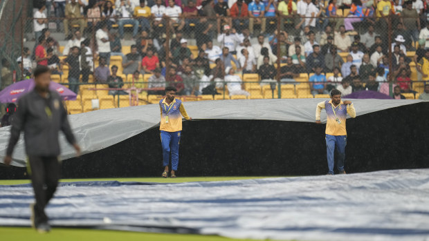 Groundsmen pull on the covers after rain stopped play on day four of the first Test match between India and New Zealand.