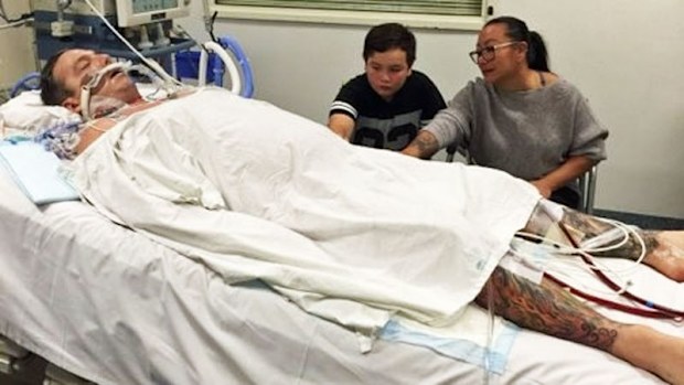 Russell Marsh in hospital with his son Ronan and wife Helen.