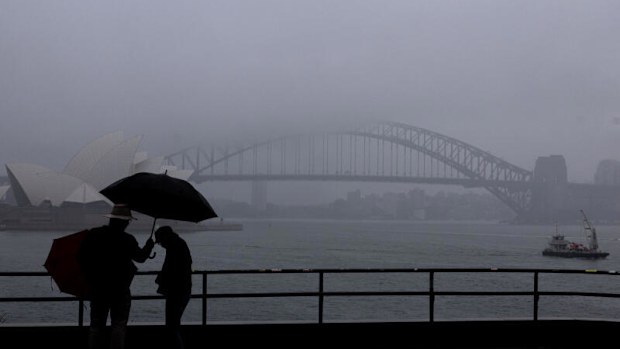 People are seen braving the rain and fog at Mrs Macquaries Chair this morning, Friday, 22 August 2025. After weeks of persistent rain, parts of the NSW coast have now recorded their wettest August in 126 years. Photo: Sam Mooy / The Sydney Morning Herald