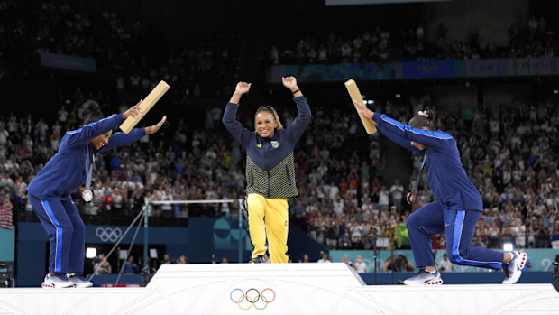 Silver medalist Simone Biles, of the United States, left, and bronze medalist Jordan Chiles, of the United States, right, bow to gold medalist Rebeca Andrade, of Brazil, 