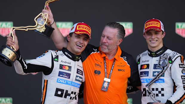 McLaren sürücüsü Lando Norris, podyumda Zak Brown ve takım arkadaşı Oscar Piastri ile kutlama yapıyor.