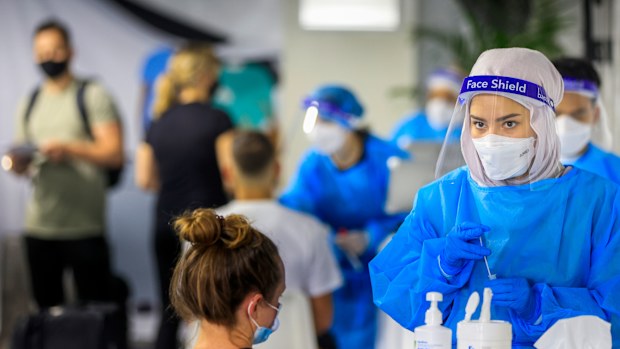 SYDNEY, AUSTRALIA - DECEMBER 23: A health worker looks on at the Histopath pre-departure COVID testing clinic at Sydney International airport on December 23, 2021 in Sydney, Australia. Demand at COVID-19 testing centres across Sydney has increased in the lead up to Christmas as NSW coronavirus case numbers rise. People travelling to Queensland, Tasmania and South Australia are required to show a negative PCR test to enter those states while Western Australia's borders are closed to NSW traveller