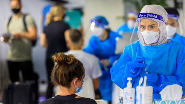 SYDNEY, AUSTRALIA - DECEMBER 23: A health worker looks on at the Histopath pre-departure COVID testing clinic at Sydney International airport on December 23, 2021 in Sydney, Australia. Demand at COVID-19 testing centres across Sydney has increased in the lead up to Christmas as NSW coronavirus case numbers rise. People travelling to Queensland, Tasmania and South Australia are required to show a negative PCR test to enter those states while Western Australia's borders are closed to NSW traveller