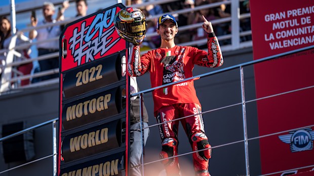 New world champion Francesco Bagnaia celebrates on the podium.