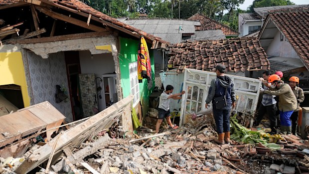 Rescuers help clear up debris from the ruins of a house damaged during Monday's earthquake in Cianjur, West Java, Indonesia, Wednesday, Nov. 23, 2022. 