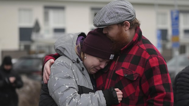 People gather at a makeshift memorial near the scene of a shooting on the outskirts of Orebro, Sweden