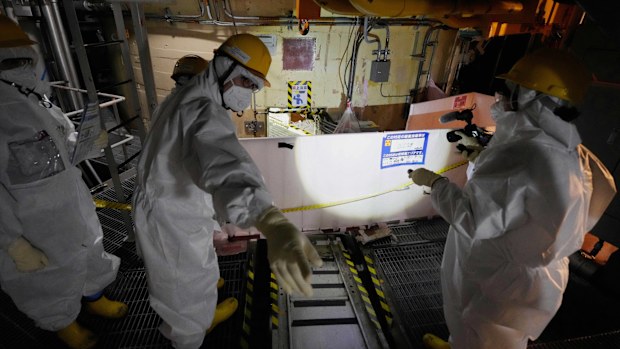 Employees of Tokyo Electric Power Company Holdings (TEPCO) take AP journalists to the area under the Unit 5 reactor pressure vessel, which survived the earthquake-triggered tsunami in 2011, at the Fukushima Daiichi nuclear power plant in Futaba town, northeastern Japan, on Monday Feb. 20, 2025. 