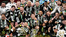 Bruno Guimaraes, Kieran Trippier, Callum Wilson, Sandro Tonali, Joelinton, Alexander Isak and staff of Newcastle United F.C. celebrate with the trophy after wining the Carabao Cup Final between Liverpool and Newcastle United at Wembley Stadium on March 16, 2025 in London, England. (Photo by Sebastian Frej/MB Media/Getty Images)