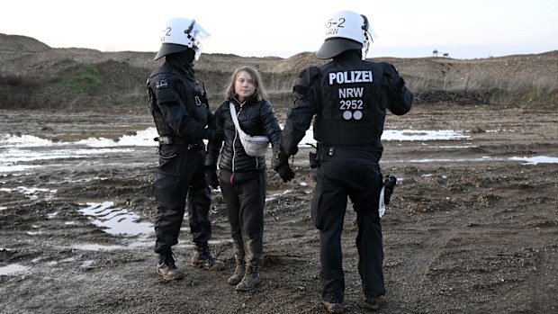 Police officers take Swedish climate activist Greta Thunberg away from the edge of the Garzweiler II opencast lignite mine during a protest action by climate activists after the clearance of Luetzerath, Germany, Tuesday, Jan. 17, 2023 