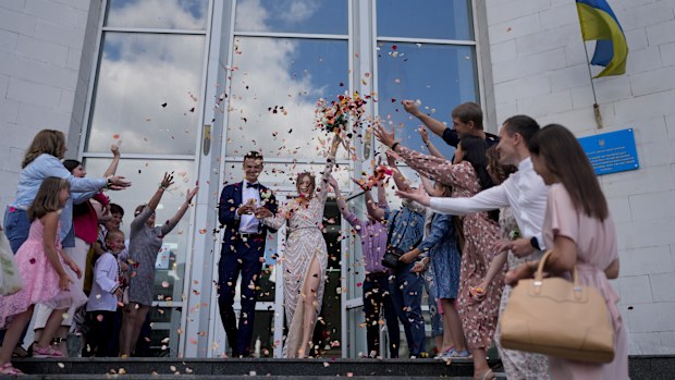 Denys Voznyi and Anna Karpenko leave after getting married in Kyiv.