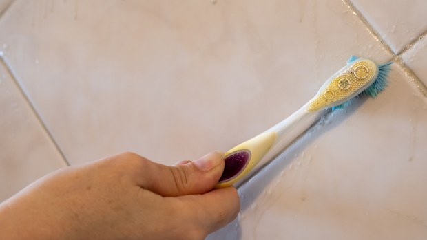 Scrubbing grout cleaning with a toothbrush