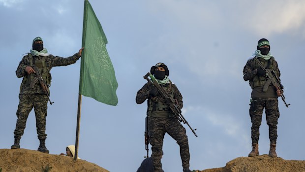 Hamas fighters take up a position ahead of handing over four bodies to the Red Cross in Khan Younis, southern Gaza Strip, Thursday, Feb. 20, 2025. Israel has identified three of the bodies as hostages and said the other was of an unknown person.  (AP Photo/Abdel Kareem Hana)