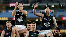Jacob Weitering and Sam Docherty are chaired off the ground.