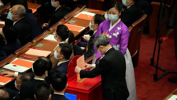 A delegate casts his vote during a session of China's National People's Congress