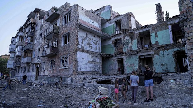People look at a house destroyed by a Russian strike in Kyiv, Ukraine, on Friday, Aug. 29, 2025. (AP Photo/Evgeniy Maloletka)