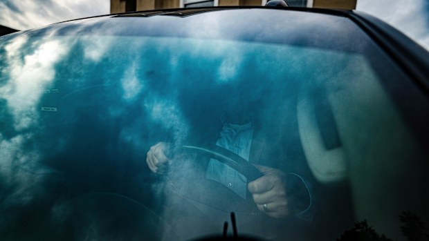 Joseph Moore sits in a pickup truck outside his home.