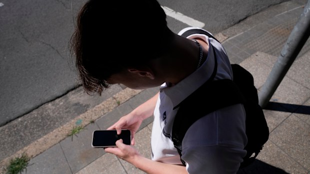 A teenage boy uses his phone for social media in Sydney, Nov. 8, 2024.