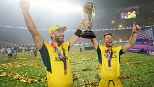 Australia's Glenn Maxwell, left, holds the trophy with teammate David Warner after Australia won the ICC Men's Cricket World Cup final match against India in Ahmedabad, India, Sunday, Nov. 19, 2023. (AP Photo/Rafiq Maqbool)