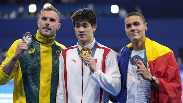 Gold medalist Pan Zhanle, of China, poses with silver medalist Kyle Chalmers, of Australia, left, and bronze medalist David Popovici, of Romania, right, after the men's 100-meter freestyle final at the 2024 Summer Olympics, Wednesday, July 31, 2024, in Nanterre, France. (AP Photo/Ashley Landis)