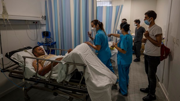 A person who was severely injured in a fuel explosion in northern Lebanon receives treatment as he lies in a hospital bed in Beirut, Lebanon